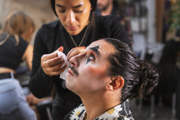 Halloween party preparations, makeup artist finishing face painting to client