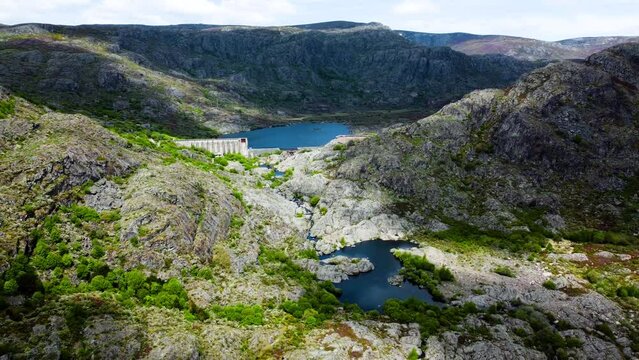 Drone pullback from dam and river of rio tera canyon, cloud shadows over water and mountain