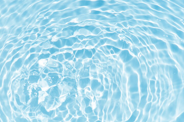 Blue water with ripples on the surface. Defocus blurred transparent blue colored clear calm water surface texture with splashes and bubbles. Water waves with shining pattern texture background.