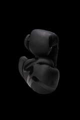 Black boxing gloves, isolated on black background, sports equipment