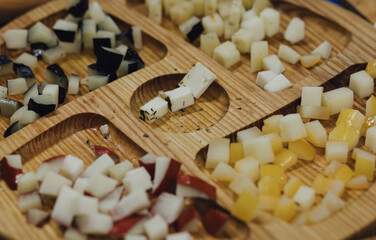 hand made baked stuffed rolls and pieces of cheese. Delicious pastries on wooden cutting board and parchment paper at the street food fair. Soft focus blurred and noise effect
