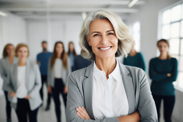 Face of beautiful middle aged business woman with grey hair on the background of business people