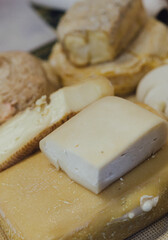 hand made baked stuffed rolls and pieces of cheese. Delicious pastries on wooden cutting board and parchment paper at the street food fair. Soft focus blurred and noise effect
