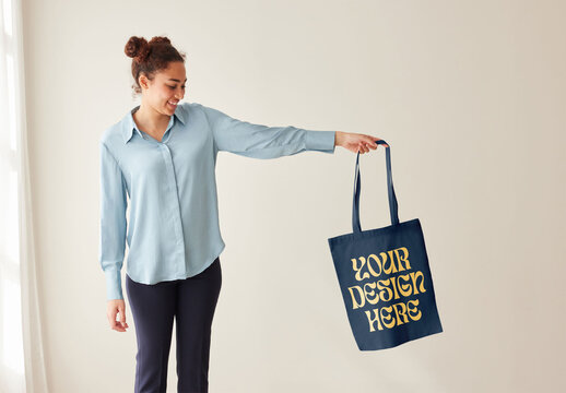 Mockup of woman holding customizable tote bag with arm out