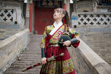 An Oriental beauty dressed in ancient warrior attire, wielding a weapon