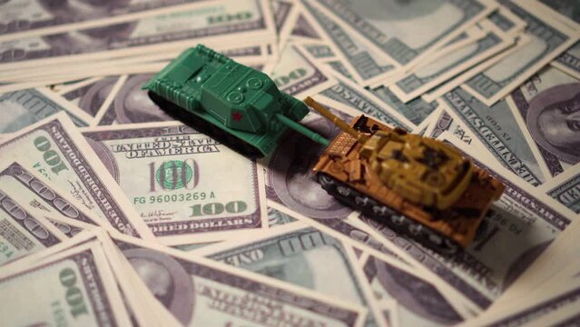 Money dollars and toy tanks. War is costly.