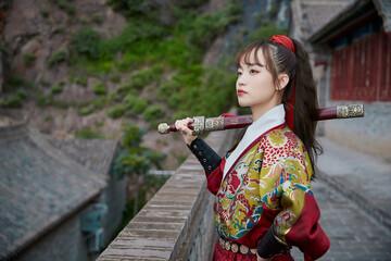 An Oriental beauty dressed in ancient warrior attire, wielding a weapon