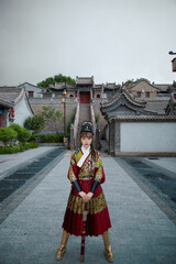 Fototapeta na wymiar An Oriental beauty dressed in ancient warrior attire, wielding a weapon