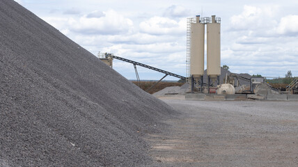 Territory of the asphalt plant. On the territory there is a pile of gravel in close-up against the...