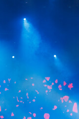 An empty concert stage illuminated by spotlights and smoke before the show.
