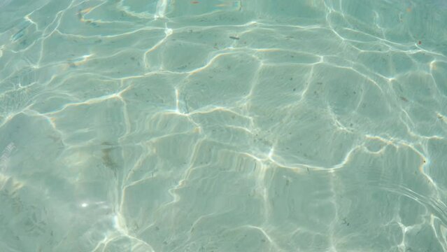 Cinematic slow motion shot of water caustics on the oceans surface with a sandy ocean floor in 4K, Slomo