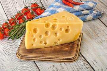 Maasdam cheese piece over board