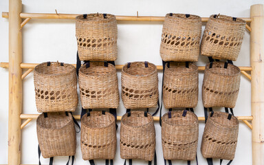 Bamboo baskets hanging on a wooden railing. Handmade bamboo basket. Tea leaf storage basket in the tea plantation, The tea storage basket
