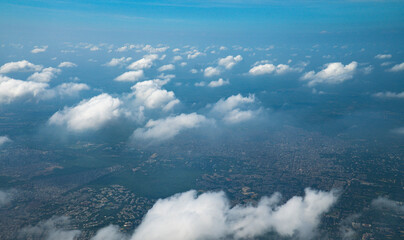 Beautiful cloudscape with blue sky. Wonderful panorama above white clouds as seen through window of an plane. Traveling by air concept