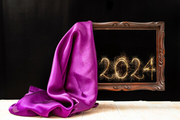 silky fabric unveiling an levitating wooden frame, with 2024 new year  number written with sparker...