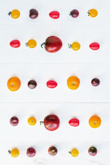 Colorful homegrown freshly picked tomatoes on wooden rustic background, top view, flat lay style. Summer organic vegetables harvest.