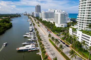 Fototapeta na wymiar Miami Beach, Florida, USA - Aerial of luxury condominiums and hotels along Indian Creek Driver in Mid Beach. Chartered yachts moored along the waterway.