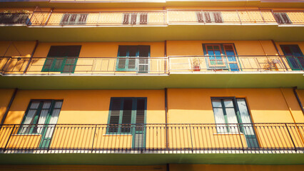 Balcony of residential building or economy hotel exterior with yellow color walls and sunlight. - 640143193