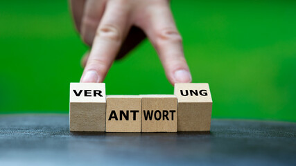 Hand dreht Holzwürfel und ändert das Wort 'Antwort' in 'Verantwortung'. Symbol dafür...