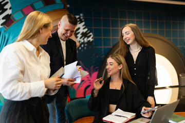 Team members enjoy playing team building activities in coworking office zone. Employees take break from work to play online games together