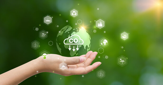 CO2 emission reduction concept.world icon in hand with environmental icons, Ideas for Sustainable development, and green business based on renewable energy. Energy saving, Sustainable development.