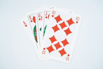 Royal straight flush playing cards poker hand in diamonds isolated on white background.