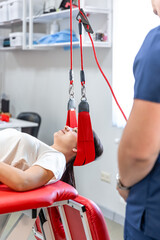 Female patient hanging on suspensions at rehabilitation center.
