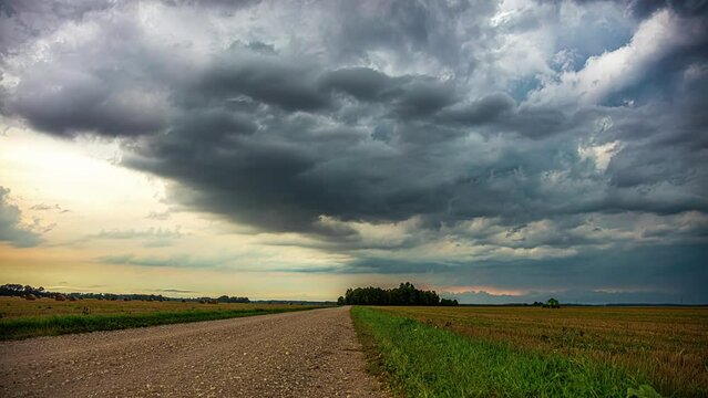Summer rainstorm as a farmer harvests crops - dramatic cloudscape time lase