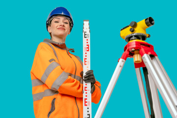 Fototapeta premium glad woman in blue hard hat and orange protective clothes land surveyor working with modern surveying geodesic instrument tachometer checking coordinates. Young woman working in construction industry