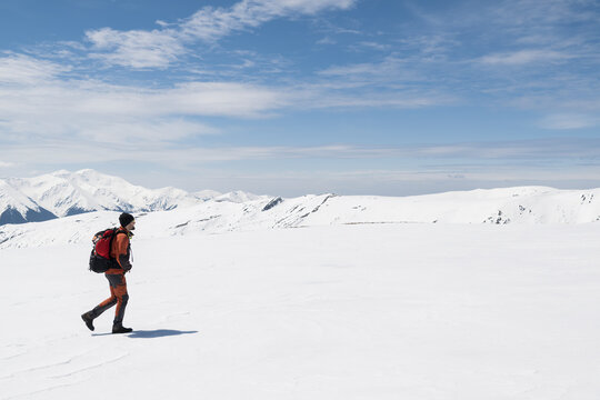 Male hiker walking in snowy mountains
