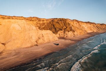 Drone photo of a single car on the beach at Denmark coastline during sunset