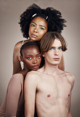 Makeup, beauty and portrait of people in studio with creative, cosmetic and facial art. Lgbtq, diversity and young man and women models with face cosmetology or skincare isolated by brown background.