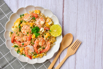 Fried rice with shrimps on a white plate, top view table, free copy space