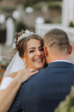 portrait of a happy wedding couple, bride and groom kissing in the autumn forest, park. Happy and smiling bride hugs groom