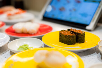 Different dish of the Japanese sushi in conveyor belt sushi shop