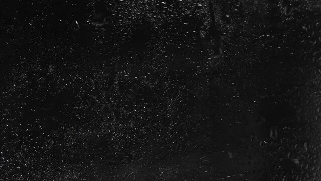 Raindrops on the window glass. Overlay template with black background.
