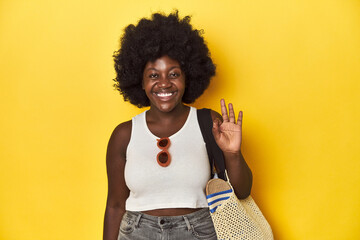 Fototapeta na wymiar Beach-ready African-American woman, summer vacation vibe cheerful and confident showing ok gesture.