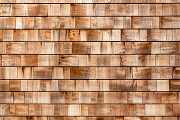 Shingle red cedar wooden shake wood siding row roof panel made of larch conifer tree. Wooden shingles background. Brown wood shingles background texture. House wall covered wooden tiles as background