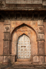 Fototapeta na wymiar Carved door of the tomb of Roza of Khadija Bibi located in Mandu, Madhya Pradesh, India