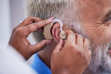 Healthcare, hands and doctor with hearing aid for man for communication support. Closeup, medical...