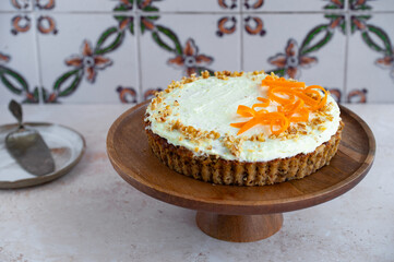 Carrot cake with cream cheese frosting and walnuts on a stone background for festive dinner. Fresh homemade carrot cake for Easter. Traditional Easter food. 
