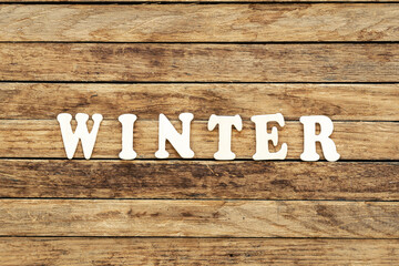 The word Winter composed of wooden letters on a wooden background.