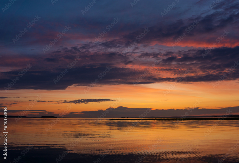 Wall mural natural landscape with a beautiful sunset over the wide northern lake