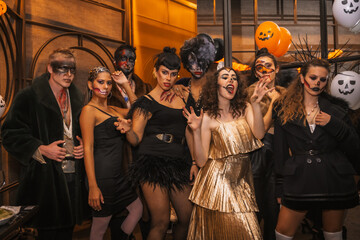 Halloween party with friends in a disco nightclub, group of friends sitting on a sofa in makeup and...