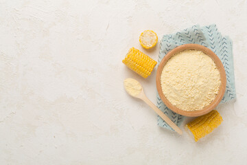 Corn flour with fresh cobs on concrete background, top view