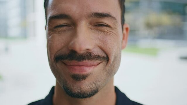 Happy guy posing street portrait. Young brunette latin man face looking camera