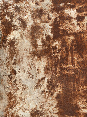 Rusty metal surface as grunge texture for background. Old door, closeup. Corroded metal plate with yellow-brown rust marks, scratches, blue oxidized spots. Worn, aged iron or steel industrial panel.
