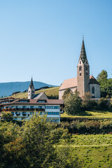 Church on a mountain overlooking valley in Villandro, Dolomites, Italy