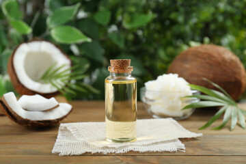 Bottle of organic coconut cooking oil on wooden table, closeup