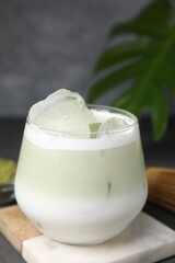 Glass of tasty iced matcha latte on table